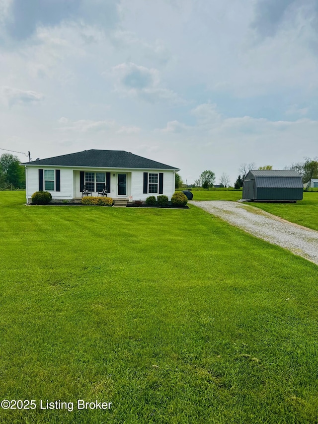 view of front of property with gravel driveway, a front lawn, and an outdoor structure