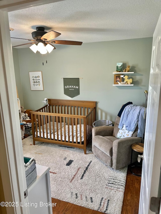 bedroom with wood finished floors, a textured ceiling, and a ceiling fan