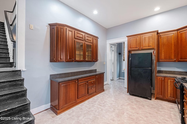 1206 S 6th St, Louisville, KY 40203 - kitchen with light floors, dark countertops, baseboards, black appliances, and brown cabinetry