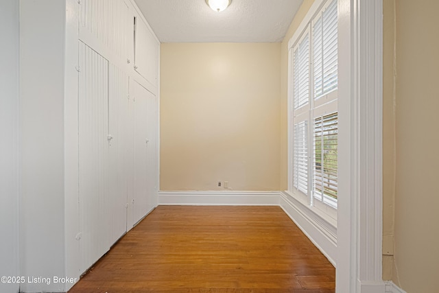 1206 S 6th St, Louisville, KY 40203 - corridor featuring wood finished floors, a textured ceiling, and baseboards