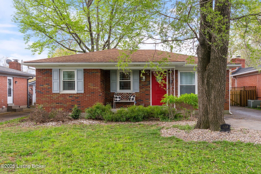 single story home with brick siding, a shingled roof, a front lawn, and fence