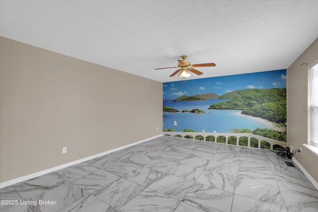 spare room featuring baseboards, marble finish floor, a water view, and ceiling fan