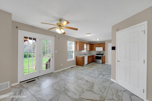 kitchen featuring visible vents, baseboards, white appliances, marble finish floor, and brown cabinets