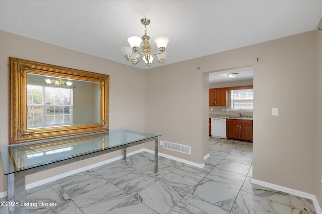 unfurnished dining area with a chandelier, visible vents, and baseboards