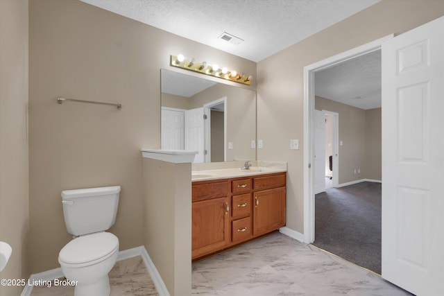 full bath featuring a sink, marble finish floor, double vanity, baseboards, and toilet