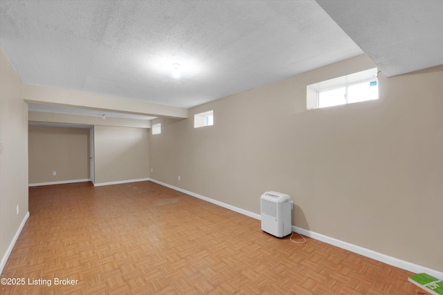 basement with baseboards and a textured ceiling