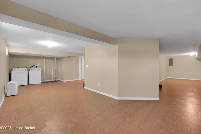 finished basement with electric panel, baseboards, and washer and clothes dryer