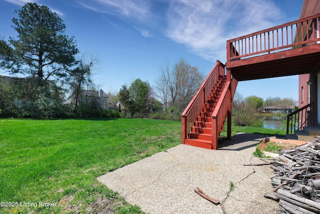 view of yard featuring a deck with water view and stairs