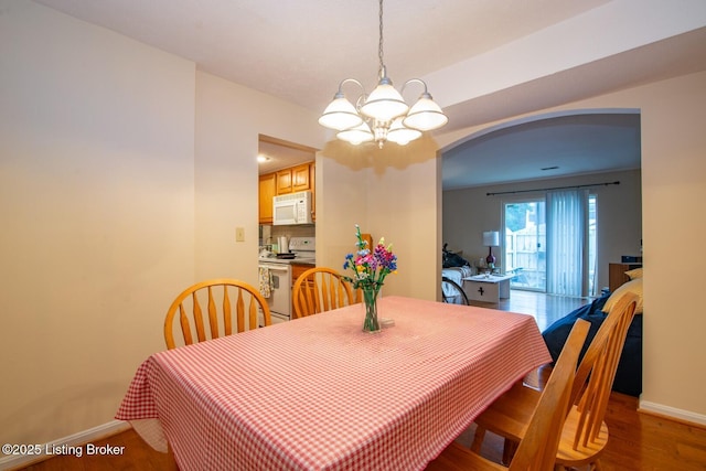 212 La Fontenay Ct, Louisville, KY 40223 - dining area featuring wood finished floors, a chandelier, baseboards, and arched walkways