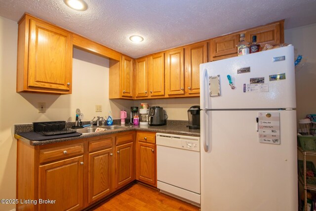 212 La Fontenay Ct, Louisville, KY 40223 - kitchen featuring a sink, white appliances, a textured ceiling, light wood finished floors, and dark countertops