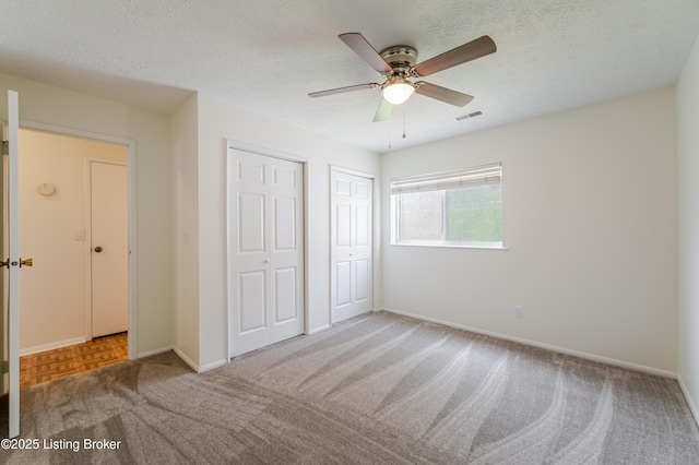 215 Bottorff Dr, Sellersburg, IN 47172 - unfurnished bedroom featuring a textured ceiling, baseboards, visible vents, carpet, and two closets