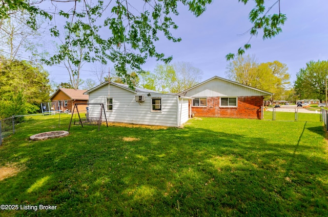 215 Bottorff Dr, Sellersburg, IN 47172 - rear view of house featuring brick siding, a trampoline, a lawn, and a fenced backyard