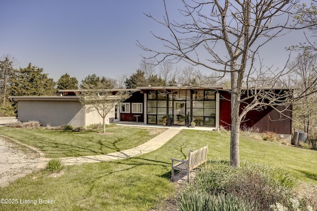 rear view of property featuring a lawn