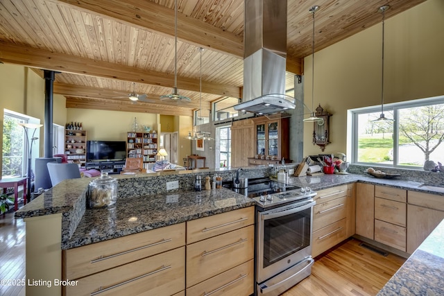 kitchen featuring light brown cabinetry, light wood-type flooring, dark stone counters, electric range, and open floor plan