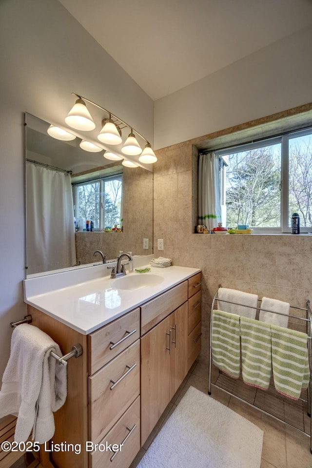 bathroom featuring tile walls, tile patterned floors, and vanity