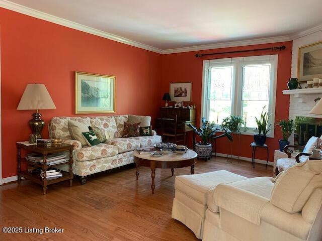 325 Rosewood Dr, Louisville, KY 40223 - living room with wood finished floors, a baseboard heating unit, crown molding, baseboards, and a brick fireplace