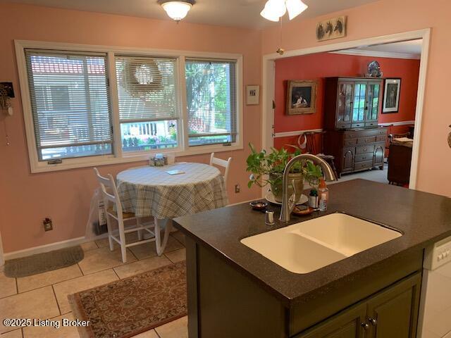 325 Rosewood Dr, Louisville, KY 40223 - kitchen with dark countertops, a sink, light tile patterned floors, dishwasher, and baseboards