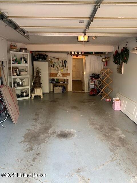 325 Rosewood Dr, Louisville, KY 40223 - garage with freestanding refrigerator and a garage door opener