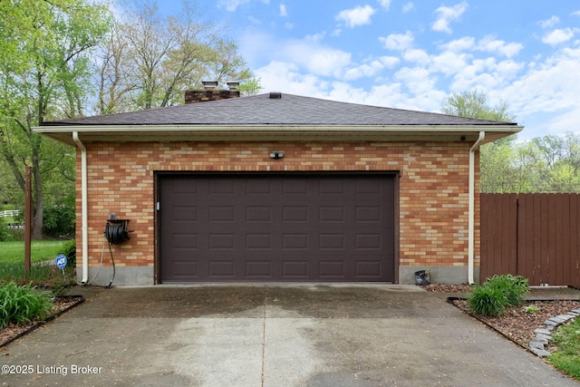 garage with driveway and fence