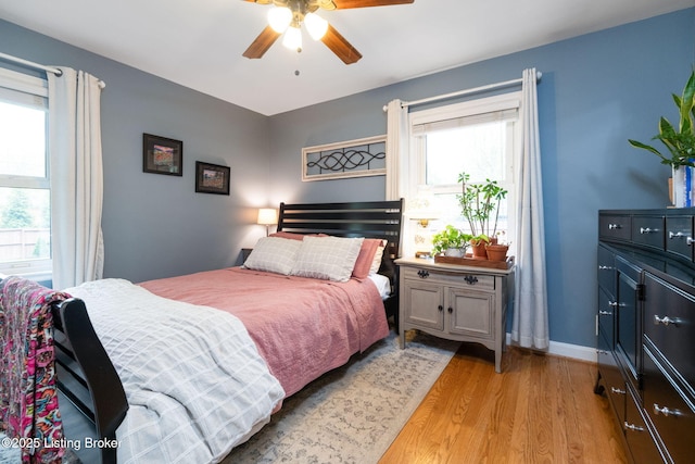 bedroom featuring light wood finished floors, baseboards, and a ceiling fan