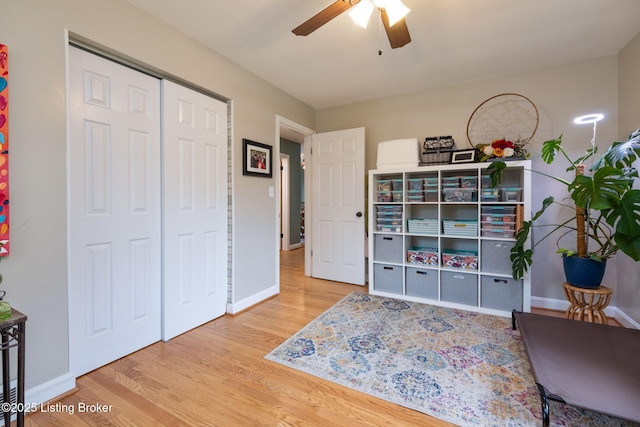 sitting room featuring baseboards, a ceiling fan, and wood finished floors