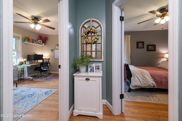 hall with baseboards and light wood finished floors