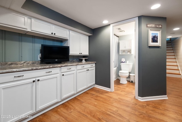 kitchen with light wood-type flooring, baseboards, white cabinetry, visible vents, and recessed lighting