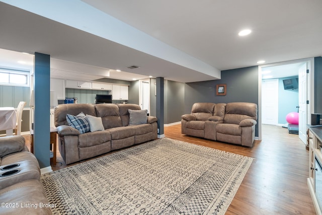 living room with light wood finished floors, baseboards, recessed lighting, and visible vents