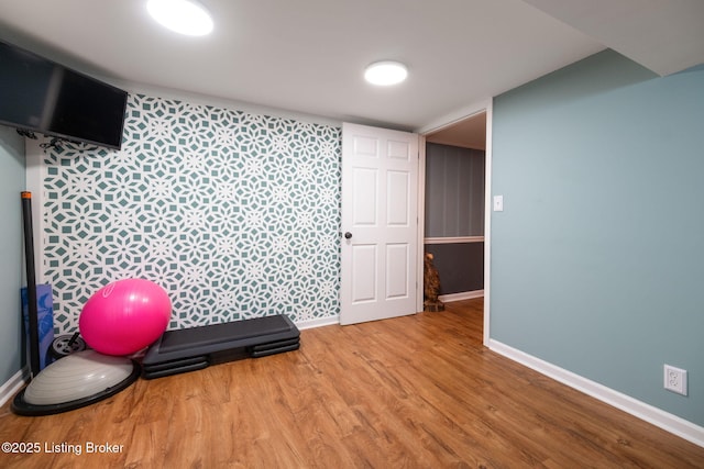 workout area featuring baseboards and wood finished floors
