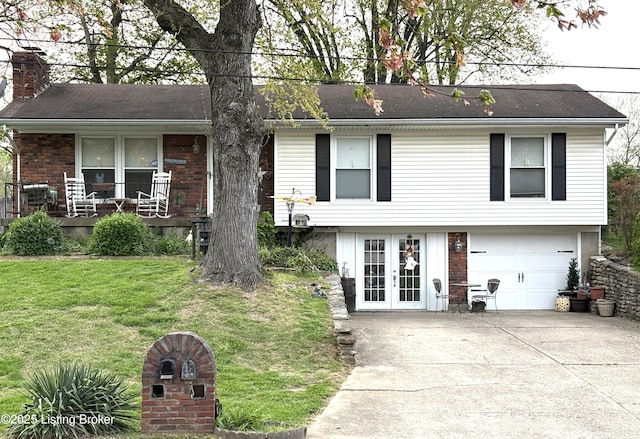 view of front of property with a chimney, an attached garage, driveway, french doors, and a front yard