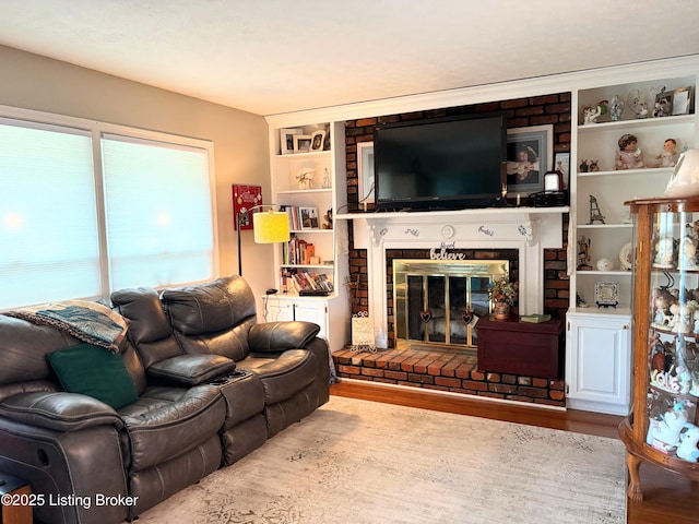 living room with a fireplace, wood finished floors, and built in features