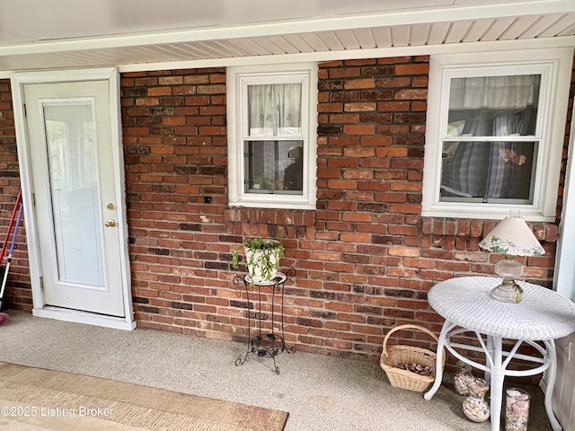 doorway to property with brick siding