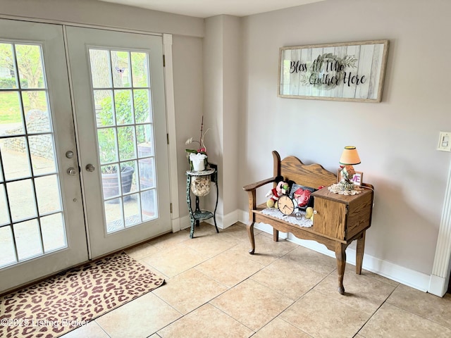 doorway with light tile patterned floors, baseboards, and french doors