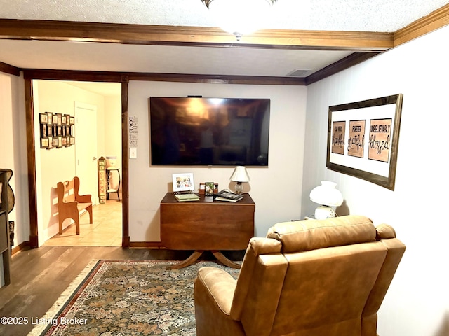 living room with beamed ceiling, wood finished floors, crown molding, and baseboards