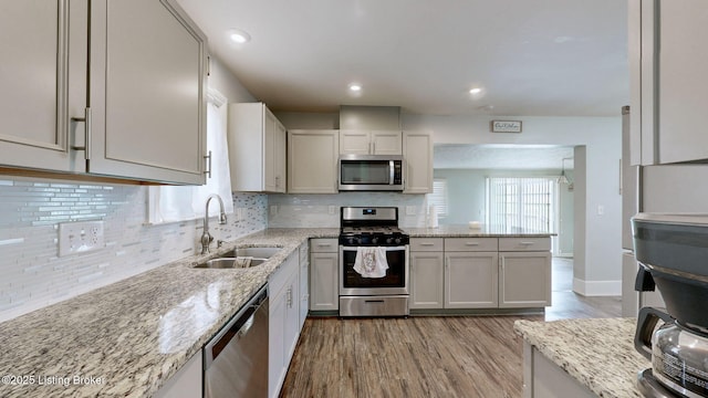 702 11th St, Carrollton, KY 41008 - kitchen with a sink, backsplash, light wood-style floors, light stone countertops, and appliances with stainless steel finishes