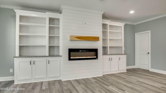 unfurnished living room featuring light wood finished floors, baseboards, recessed lighting, a large fireplace, and crown molding