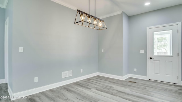 unfurnished dining area featuring crown molding, wood finished floors, baseboards, visible vents, and recessed lighting