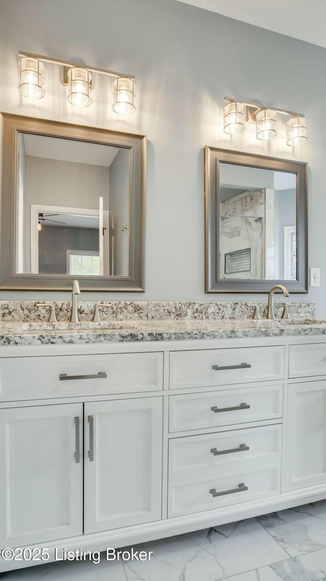 bathroom featuring double vanity, marble finish floor, and a sink
