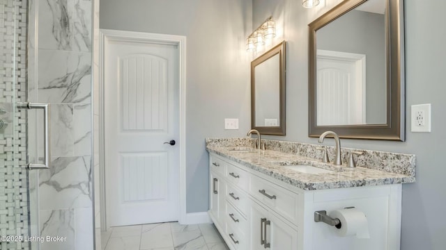 bathroom featuring double vanity, marble finish floor, a marble finish shower, and a sink