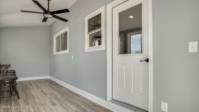 interior space featuring baseboards, lofted ceiling, and wood finished floors