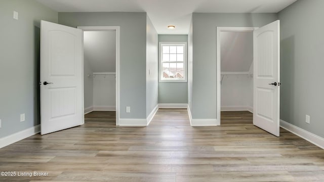 unfurnished bedroom featuring light wood-type flooring, a closet, and baseboards