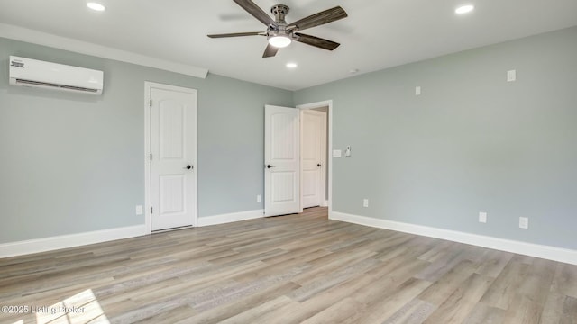 unfurnished bedroom with recessed lighting, a wall mounted AC, light wood finished floors, and baseboards