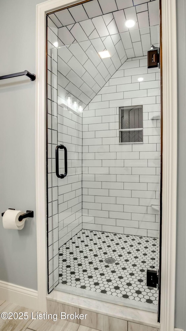 full bath with baseboards and a stall shower