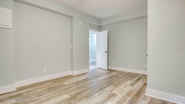 spare room featuring light wood finished floors and baseboards