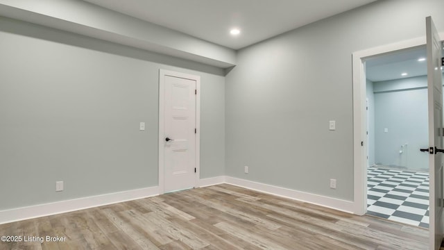 empty room with baseboards, light wood-type flooring, and recessed lighting