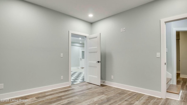 unfurnished room featuring light wood-type flooring, baseboards, and recessed lighting