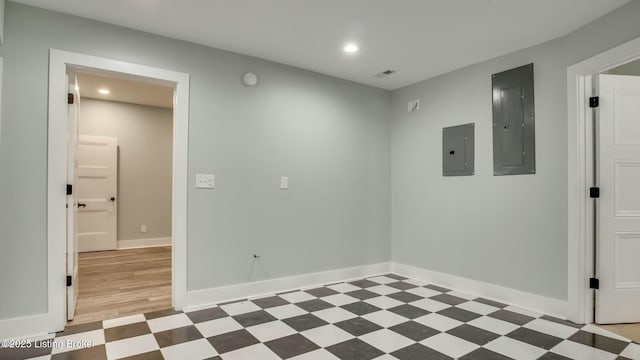 unfurnished room featuring light floors, baseboards, electric panel, and recessed lighting