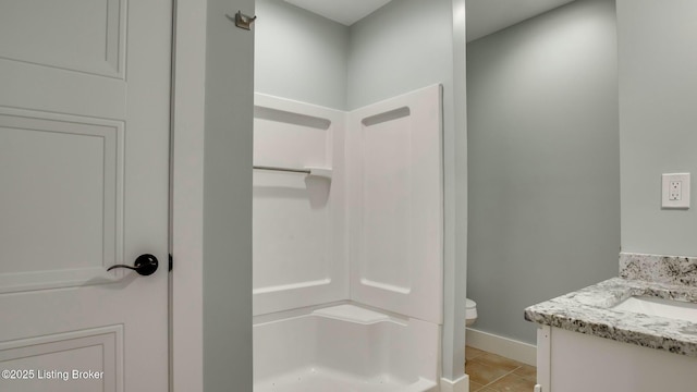 full bathroom featuring toilet, baseboards, tile patterned flooring, a shower, and vanity