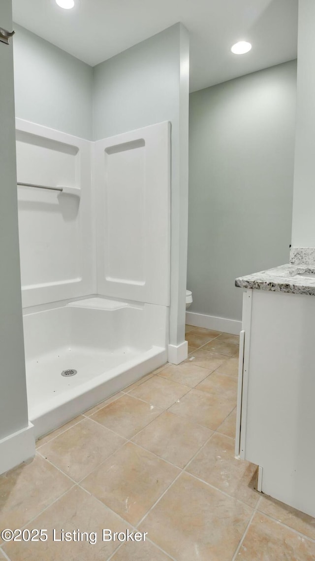 bathroom featuring a shower stall, toilet, tile patterned flooring, and vanity