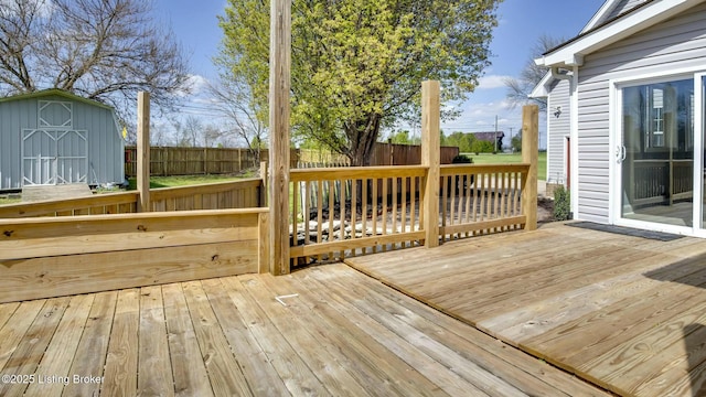 deck featuring a fenced backyard, an outbuilding, and a storage shed